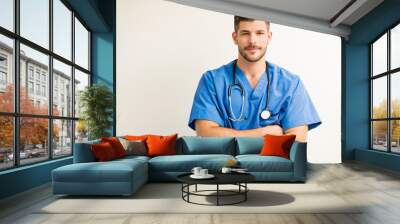 Portrait Of Young Surgeon Isolated Against Plain Background Wall mural