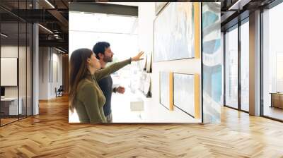 Side view of an attractive couple visiting an art gallery Wall mural