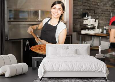 Smiling chef holding big shovel with pizza Wall mural