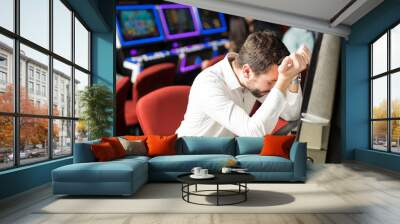 Stressed man losing money in a casino Wall mural