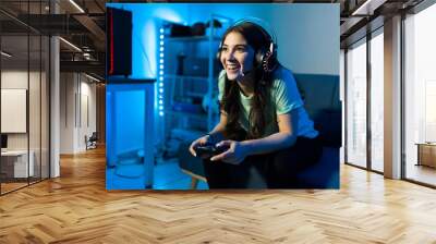 Woman gamer smiling while talking to an online player Wall mural