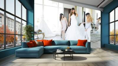 Women Admiring White Wedding Gown In Store Wall mural