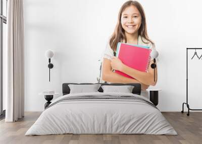 Young hispanic student girl holding books Wall mural