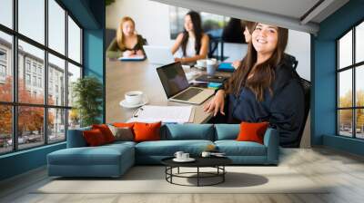 Young woman at a work meeting feeling happy Wall mural