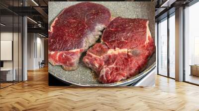 Fresh raw beef steak in frying pan on oven cooking Wall mural