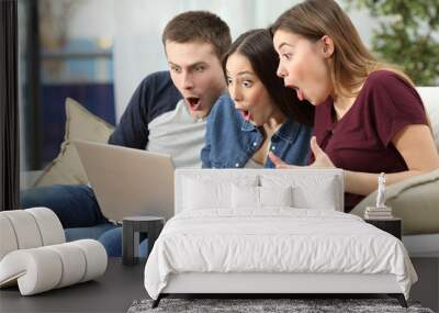 Amazed friends watching content on line in a computer Wall mural