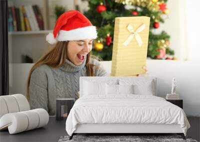 Amazed woman opening a gift box on christmas Wall mural