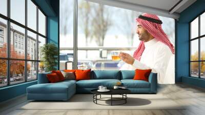 Arab man enjoying a cup of tea in a coffee shop Wall mural