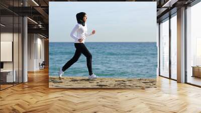 Arab saudi runner woman running on the beach Wall mural