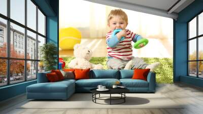 Baby biting toys on a carpet Wall mural