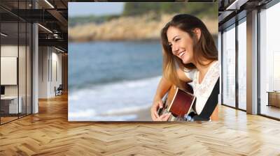 Beautiful guitarist woman playing guitar on the beach Wall mural