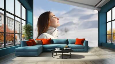 explorer woman breathing fresh air in winter in a snowy mountain Wall mural