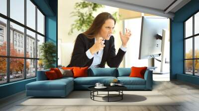 Furious businesswoman using a computer Wall mural