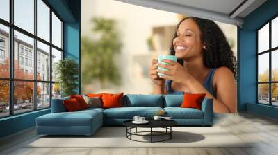 Happy black woman breathing drinking coffee at home Wall mural