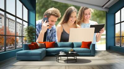 Happy friends using multiple devices on a bench Wall mural