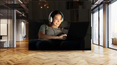 Happy girl elearning online with a laptop in the night Wall mural