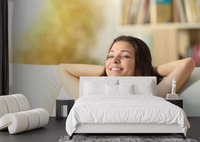 Happy relaxed girl resting at home on a couch Wall mural