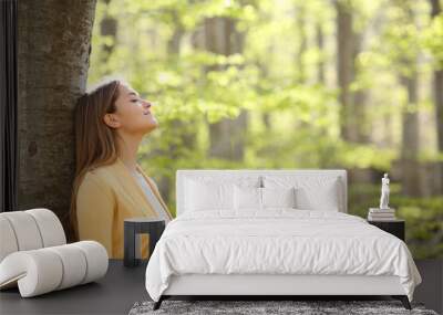 Relaxed woman breathing fresh air in a green forest Wall mural