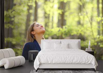 Relaxed woman breaths fresh air in a forest Wall mural