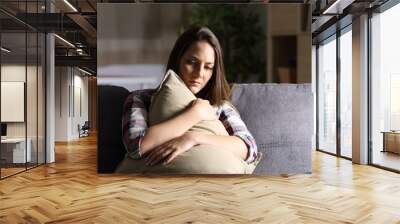 Sad girl embracing a pillow at home Wall mural