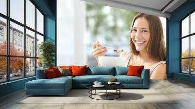 woman eating cornflakes at home Wall mural