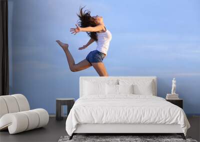 Woman jumping on the sand of the beach Wall mural