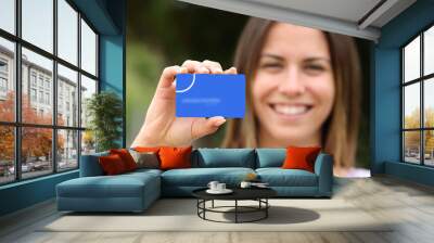 Woman showing blank credit card Wall mural