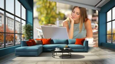 Woman watching a laptop in a restaurant Wall mural