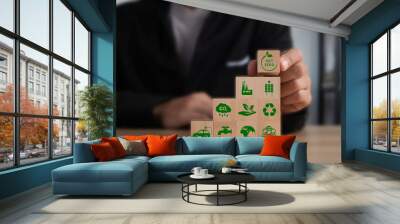 Businessman puting wooden cubes with green net zero icon on table. Net zero and carbon neutral concept. Net zero greenhouse gas emissions target. Climate neutral long term strategy. Wall mural