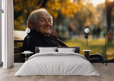 smiling elderly man with hearing aid enjoys sunny day in park Wall mural