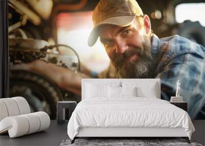 a cheerful mechanic with a beard and a baseball cap, working on a large truck engine. Wall mural