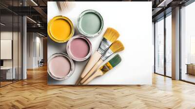 Open paint cans with pastel colors, paintbrushes dipped, arranged artistically on white surface. Wall mural