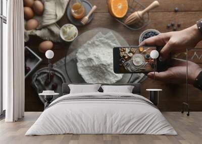 The top view of the hand take photo of ingredients and method bakery or dessert with the smartphone on the table. Tutorial food photography, A lifestyle to social media.Flat lay photography. Wall mural