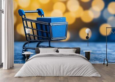 Miniature Shopping Cart with Blue Box on Wooden Surface. Wall mural