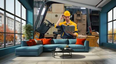 Caucasian engineer using a laptop in a factory. man working in plastics factory. Wall mural