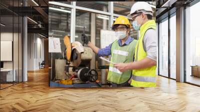 engineering working in factory concept.Two engineer worker working together with safety uniform. Factory worker and female manager discussing about work in metal industry factory. Wall mural