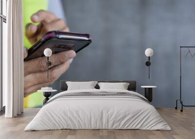 construction worker hands using smartphone on cement wall background with copy space Wall mural