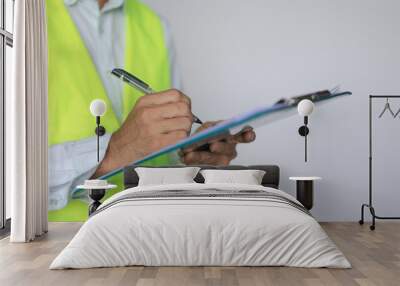 Construction worker inspector checking notes in clipboard, Engineer checking and inspecting with clipboard at indoor construction site construction inspection, contractor and engineering concept Wall mural