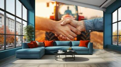 Two farmers shake hands in a sunlit field with a tractor in the background, symbolizing a successful partnership Wall mural