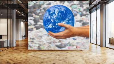 The hands of men holding the globle on garbage background . Ecology concept, earth day. Elements of this image furnished by NASA Wall mural