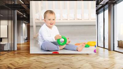 little boy 2 years old playing near the crib, early development Wall mural