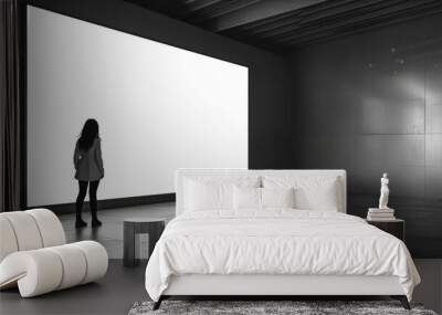 a woman watching a giant empty white screen mock-up. Wall mural