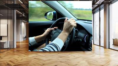 Wrong position of man’s hands on the steering wheel inside fast moving vehicle
 Wall mural