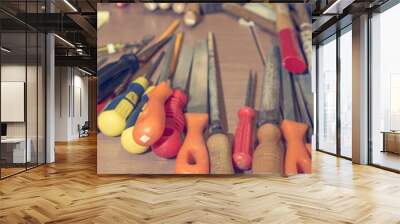 Different hand tools stacked on a wooden table. Wall mural