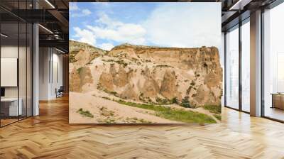 Rocky ridge with dwellings cut into it Wall mural