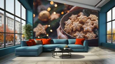 Close up of hands holding Christmas gingerbread cookies against a festive decoration background banner Wall mural