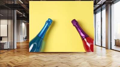 Shimmer edible glitter sparkling pink and blue champagne in two bottles on yellow background. Space for text. Wall mural