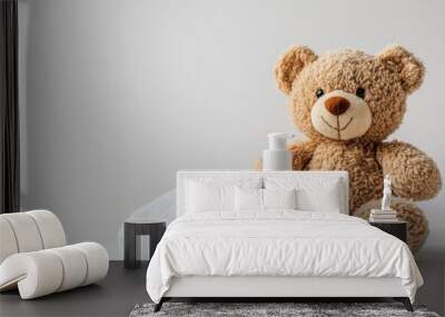 A cheerful teddy bear sitting beside baby shampoo and a soft towel, creating a soothing bath environment for little ones Wall mural