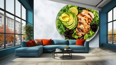 Fresh avocado and grilled chicken salad served on a bed of leafy greens in a modern bowl Wall mural