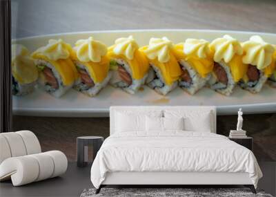 delicious sushi roll with salmon avocado and white fish topped with mango and sauce Wall mural